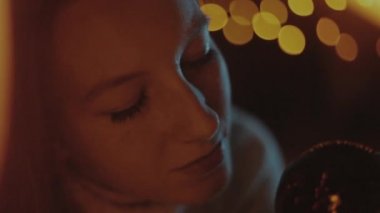 genç kız bir kırmızı yılbaşı balosunda, Noel ışıkları görünüyor.