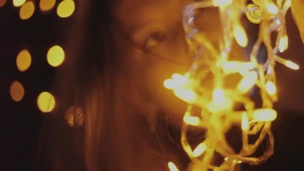 Belle jeune fille tenant une guirlande jaune, lumières de Noël .