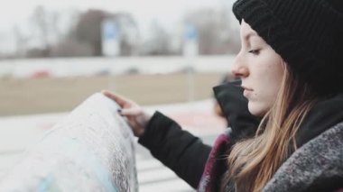 Doğru sokak bulmak için turist haritası arıyorsunuz güzel ve genç birbayan. Turist kız aroung sokak harita ile