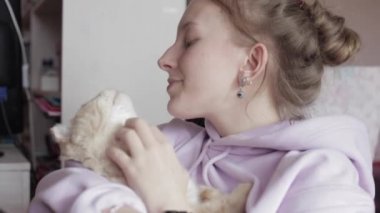 Genç kız evde beslenen hayvan ile oynuyor. Sarılma ve kedi ile oynarken kız. Ev konfor.