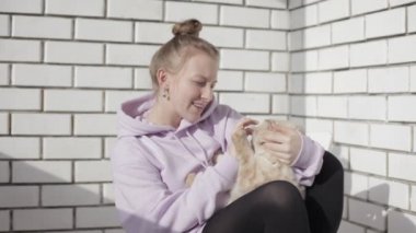 Genç kız evde beslenen hayvan ile oynuyor. Sarılma ve kedi ile oynarken kız. Ev konfor.