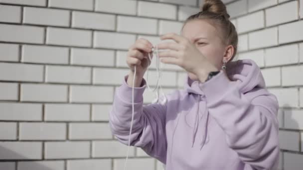 Girl Unravels Headphones on a white background — Stock Video