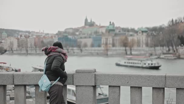 Mädchen auf Brücke denken sich und schauen auf Fluss. Norwegerin starrt bei Prag in die Ferne. — Stockvideo