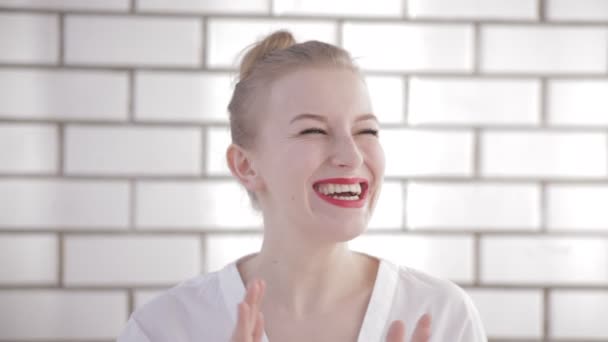 Joven mujer atractiva en una blusa blanca se ríe alegremente. Mujer muestra emociones alegres — Vídeos de Stock