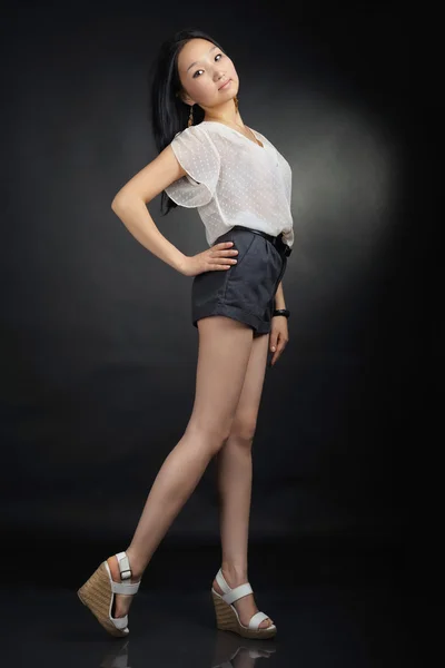 Aziatische meisje in T-shirt en shorts op zwart — Stockfoto