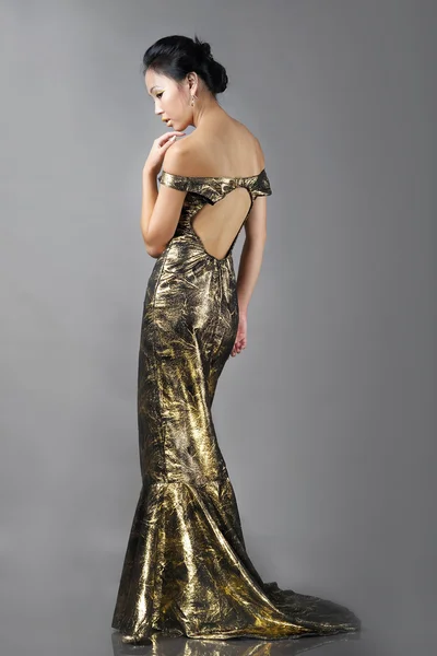 Asiatische Frau in langen schönen goldenen Kleid — Stockfoto