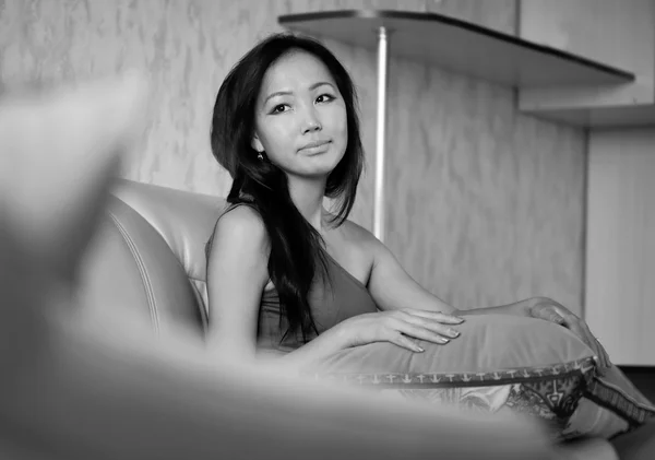 Ázsiai nő ül a kanapén — Stock Fotó