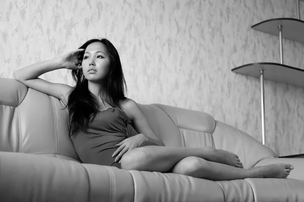 Θλιβερή ασιατική γυναίκα στον καναπέ — Φωτογραφία Αρχείου