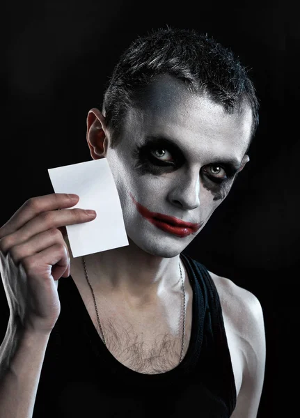 Ürkünç adam tutun boş kağıt üzerinde siyah arka plan — Stok fotoğraf
