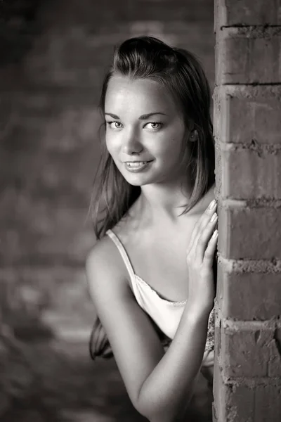 Beautiful woman near brick wall — Stock Photo, Image