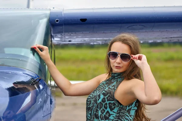 Vrouw poseren in de buurt van vliegtuig — Stockfoto