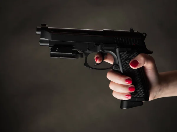 Pistol i kvinnlig arm — Stockfoto