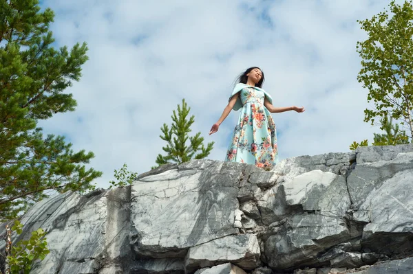 Giovane donna in abito lungo posa alla roccia di marmo — Foto Stock