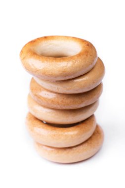 Küçük kuru simit yığını, beyaz arka planda izole edilmiş ekmek halkaları.