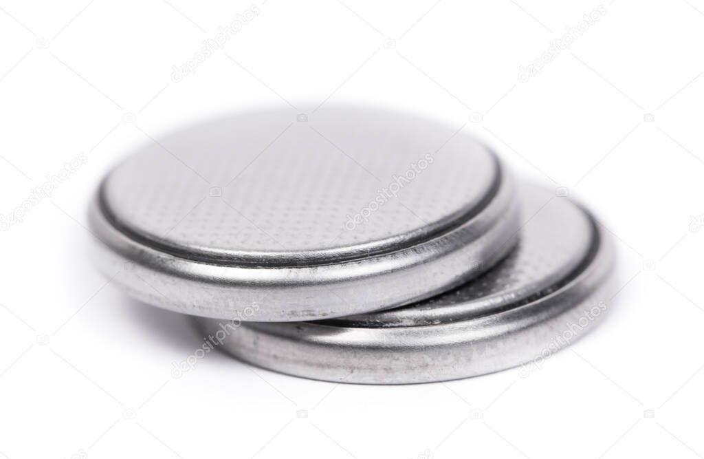 Flat lithium round button cell battery isolated over white background