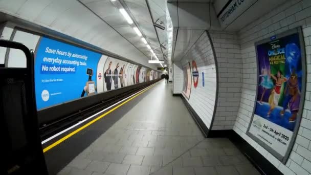 Londra, Marea Britanie, 20 martie 2020: Intrarea în hiperlapsul platformei stației goale care se deplasează pe stația de metrou cu unii oameni la blocarea coronavirusului — Videoclip de stoc