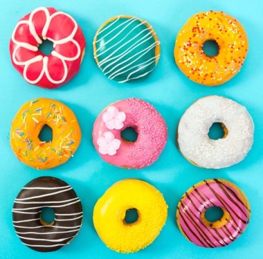 Various colorful donuts on blue background.   clipart