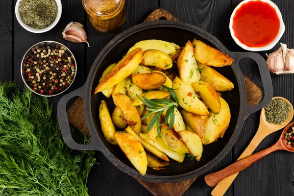 Fried potatoes with fresh rosemary in cast-iron pan. Top view. — Stock Photo, Image