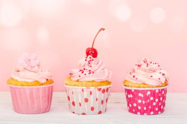 Satır krem ve süslemeleri ile üç cupcakes 