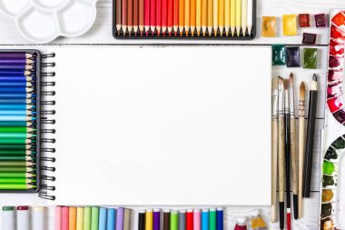 Beyaz ahşap zemin üzerinde sanatçı çalışma alanı. 