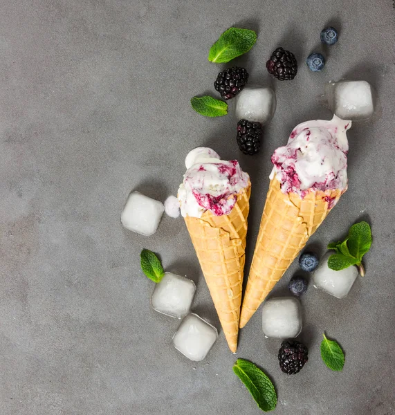 Fruit ice cream with fresh blackberry and blueberry, ice cubes a