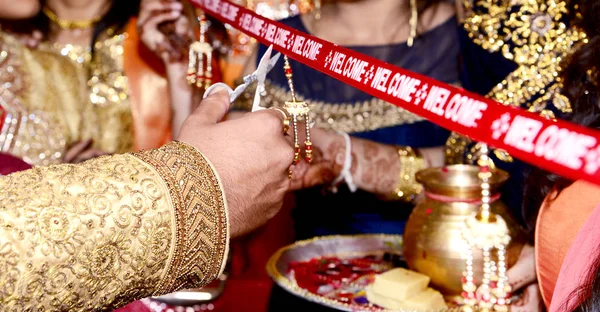 Cutting Ribbon in Indian Wedding Ritual Welcome Ceremony