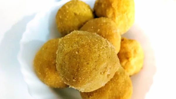 Tatlı bir ağız sulandırıcı - Kızarmış gram un, ghee, kuru meyve ve şeker ile yapılan Besan laddoo, beyaz bir kasede servis edilir.. — Stok fotoğraf