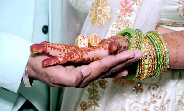 Uma noiva e noivo indiano segurando suas mãos com anel durante um ritual de casamento hindu — Fotografia de Stock