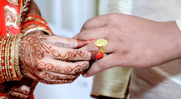 Индийская невеста надевает обручальное кольцо на палец жениха — стоковое фото