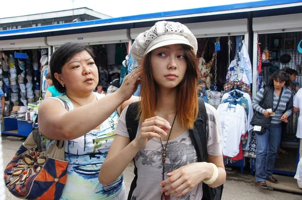 Азиатка примеряет шляпу. — стоковое фото