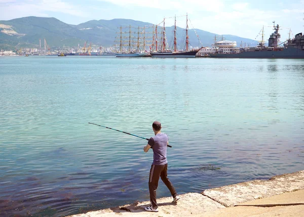 Pescadores con cañas de pescar en el muelle, dedicados a la pesca . — Foto de Stock