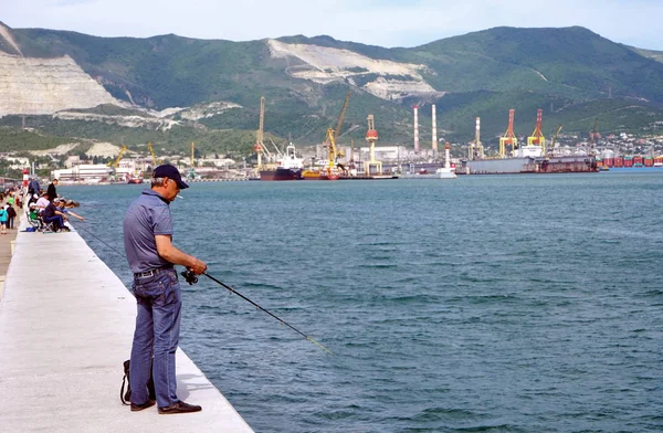 Pescadores con cañas de pescar en el muelle, dedicados a la pesca . — Foto de Stock