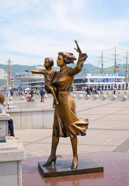Bir denizcinin karısının anıtı. Kollarında çocuğu olan bir kadının bronz heykeli, limanın karşısında.. — Stok fotoğraf