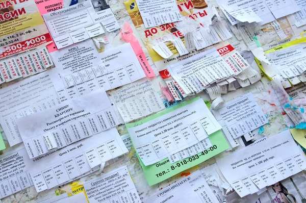 Anúncios de papel são colados na parede. Aluguer, venda de habitação . — Fotografia de Stock