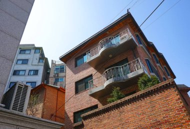 Seul, Mart 2019: Balkonlu tuğla bir evin cephesi, alışılmadık bir atış açısı..