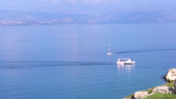 2隻のボートが互いに会うために航海する。湾の眺め、遠くに水、木、山の青い広がり. — ストック動画