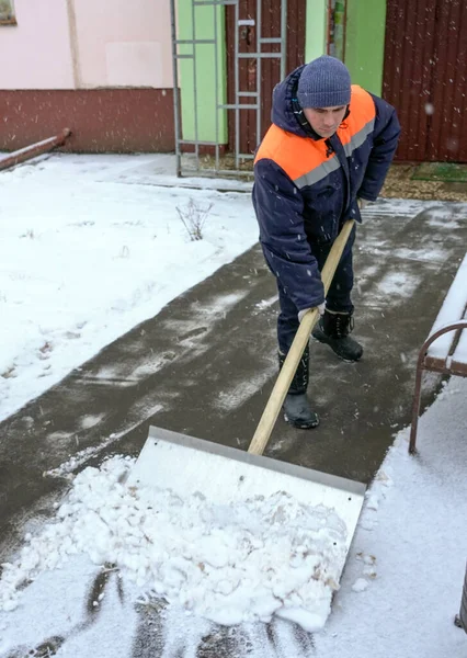 Travailleurs en uniforme avec de grosses pelles. Déneigement des rues de la ville . — Photo