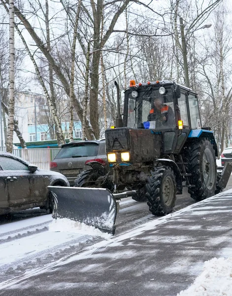 Tractor remove a neve da estrada. Remoção de neve nas ruas . — Fotografia de Stock