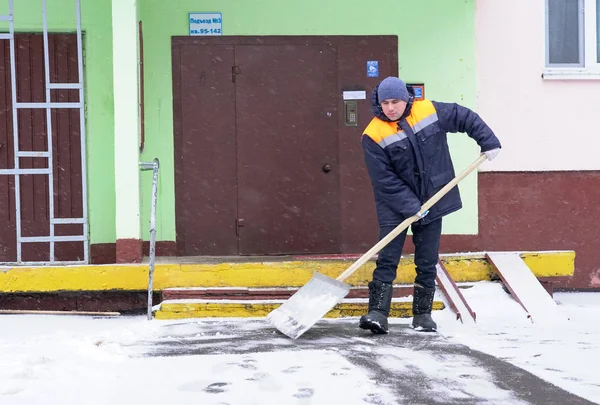 Trabajadores en uniforme con grandes palas. Eliminación de nieve en las calles de la ciudad . — Foto de Stock