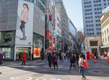 Sokaktaki insanlar, dükkanlar, açık hava reklamları. Myeongdong Alışveriş Sokağı.