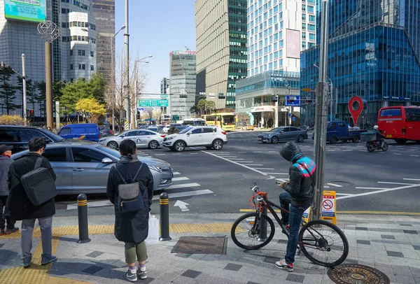 サイクリストはソウル中心部の交差点に位置し、オフィスビルも高い — ストック写真
