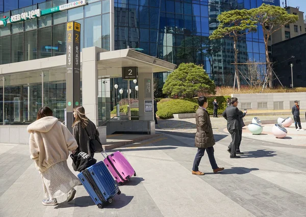젊은 일본 관광객 두 명 이큰 여행 가방을 들고 지하철역을 지나간다. — 스톡 사진