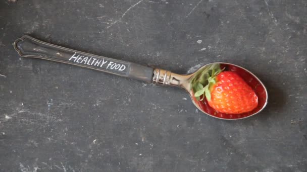 Texto de comida saludable, cuchara y fresa en la mesa vintage — Vídeo de stock