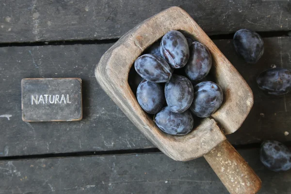 Natuurvoeding idee, pruimen op oude landelijke achtergrond en tekst — Stockfoto