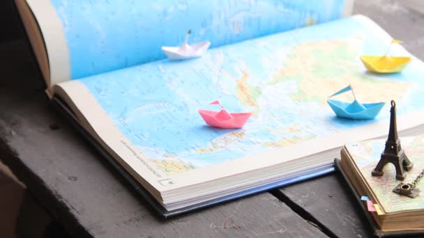 Tour Packages or Travel agent idea. Paper boats on the map and the Eiffel Tower. — Stock Video