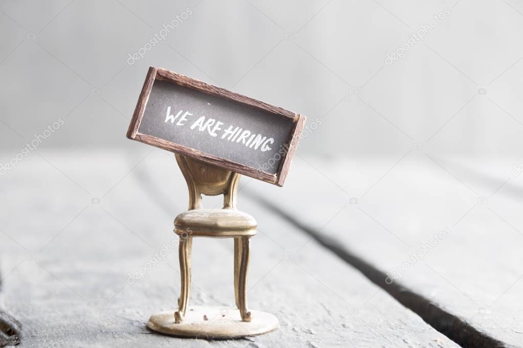 Were hiring written on chalkboard and chair