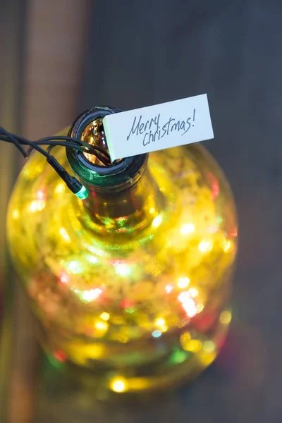 Merry Christmas card - napis i butelki z wianka — Zdjęcie stockowe