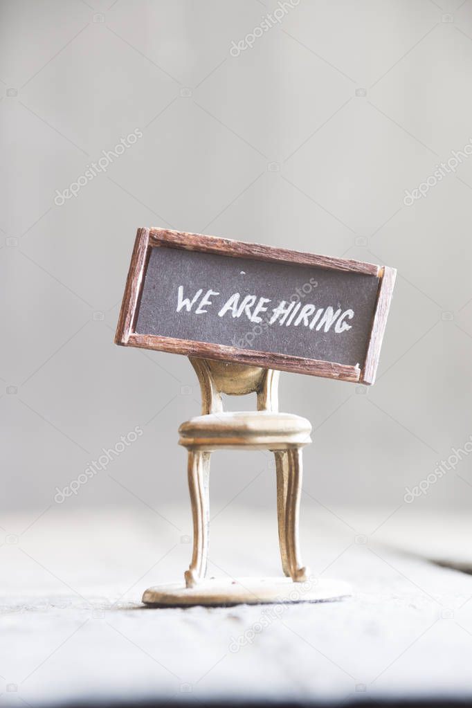 Job recruiting idea WE ARE HIRING - texts on the golden chair