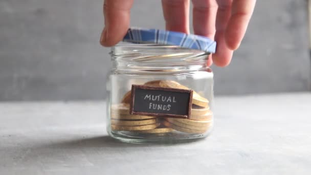 Writing MUTUAL FUNDS, and money in jar — Stock Video