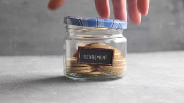 Etiqueta de retiro y monedas en un frasco de vidrio. Ahorre dinero fondo de jubilación para la idea de pensiones . — Vídeos de Stock